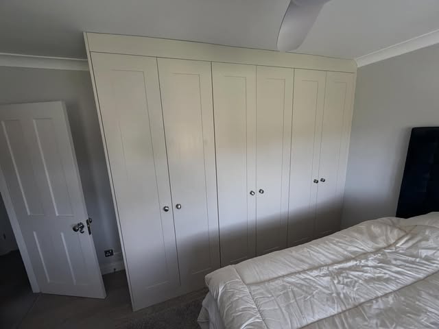 Wall of painted shaker-style fitted wardrobes